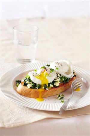 food served - Poached egg cracked open on top of toast with leafy greens and cheese Stock Photo - Premium Royalty-Free, Code: 600-09119460