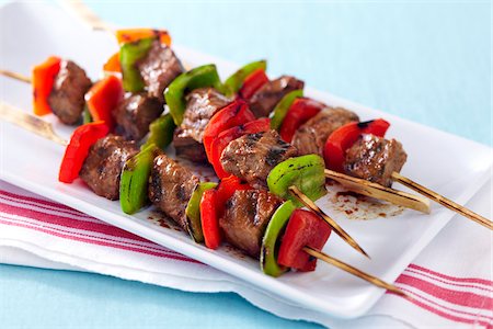 simsearch:600-09118287,k - Grilled steak and pepper skewers on a platter with red striped napkin Photographie de stock - Premium Libres de Droits, Code: 600-09119475