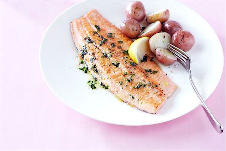 simsearch:600-09119472,k - Fillet of trout with lemon herb butter and baby potatoes on a pink background Stock Photo - Premium Royalty-Free, Code: 600-09119483