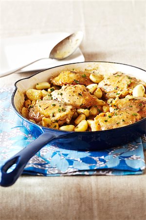 Blue skillet of chicken thighs with garlic on a patterned tea towel Foto de stock - Sin royalties Premium, Código: 600-09155479