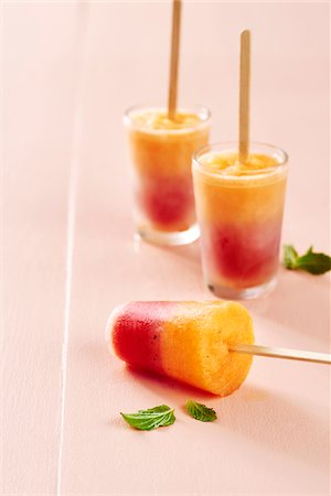 Homemade fruit ice pops with mint on a peach background Stock Photo - Premium Royalty-Free, Code: 600-09155572