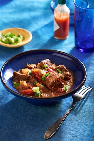 Texas style chili in a blue bowl with a fork on a blue background Stock Photo - Premium Royalty-Free, Code: 600-09155599