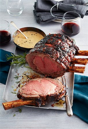 slab of roast - Standing rib roast with bearnaise sauce and glasses of red wine Stock Photo - Premium Royalty-Free, Code: 600-09155593