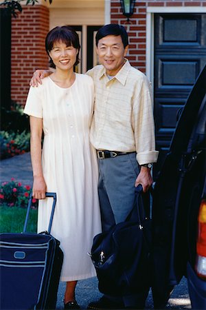 Portrait of Mature Couple in Front of House with Luggage Stock Photo - Premium Royalty-Free, Code: 600-00055935