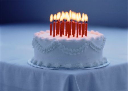 Cake with Lit Candles on Corner Of Table Stock Photo - Premium Royalty-Free, Code: 600-00057103