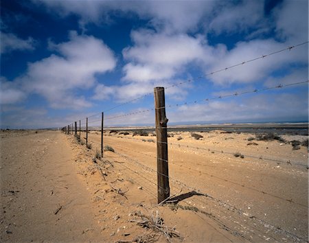 fil barbelé - Clôture en fil de fer barbelé et paysage, Alexander Bay, Afrique du Sud Photographie de stock - Premium Libres de Droits, Code: 600-00057162