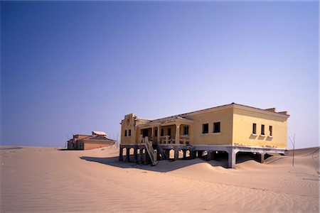 Deserted Buildings on Sand Dune, Baia dos Tigres, Angola Foto de stock - Sin royalties Premium, Código: 600-00074393