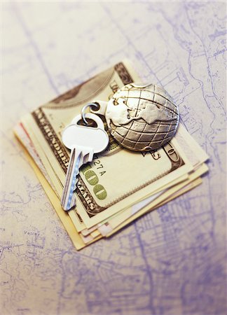 Key with Globe Keychain on Stack Of Currency on Map Stock Photo - Premium Royalty-Free, Code: 600-00073207
