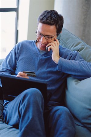 shopping laptop eyeglasses - Man Using Telephone Stock Photo - Premium Royalty-Free, Code: 600-00177154