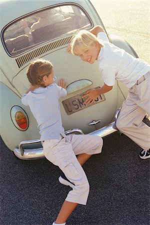 pigtail girl and brother - Children Pushing Car Foto de stock - Sin royalties Premium, Código: 600-00795573