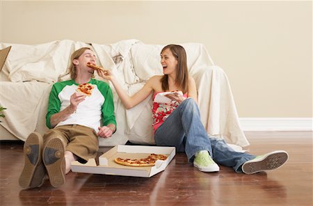 photo of a woman feeding her husband food - Woman Feeding Man Pizza Stock Photo - Premium Royalty-Free, Code: 600-00824330