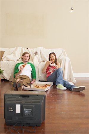 dinner on the couch - Couple Watching Television and Eating Pizza Stock Photo - Premium Royalty-Free, Code: 600-00824331