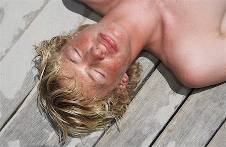 Young Man Lying On Deck Stock Photo - Premium Royalty-Free, Code: 600-00824673