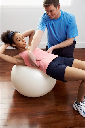 Large group of women training in gym with male trainer, in rows