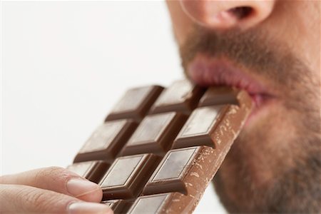 eat mouth closeup - Man Eating Chocolate Bar Stock Photo - Premium Royalty-Free, Code: 600-00823124