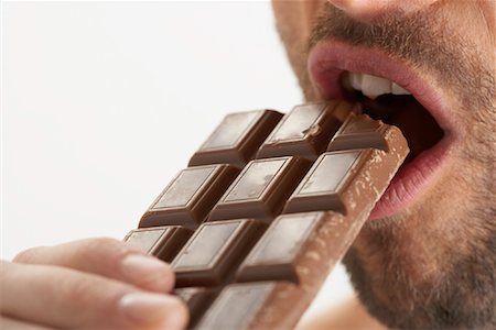 simsearch:600-00846410,k - Man Eating Chocolate Bar Foto de stock - Sin royalties Premium, Código: 600-00823125