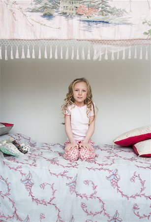 Portrait of Girl Sitting on Bed Stock Photo - Premium Royalty-Free, Code: 600-00823698
