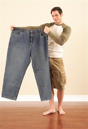Man Holding Oversized Pants Stock Photo - Premium Royalty-Free, Code: 600-00846060