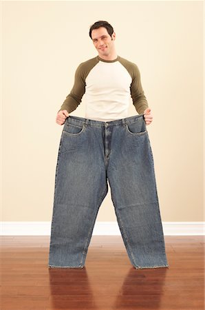 Man Holding Oversized Pants Stock Photo - Premium Royalty-Free, Code: 600-00846061