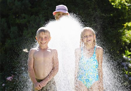 silly parent tween - Children Being Sprayed With Garden Hose Stock Photo - Premium Royalty-Free, Code: 600-00847725
