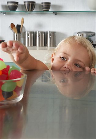 Child Reaching For Candy Stock Photo - Premium Royalty-Free, Code: 600-00848626