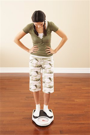 Woman Standing on Scale Stock Photo - Premium Royalty-Free, Code: 600-00866792