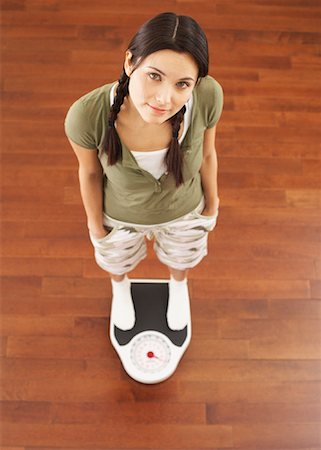 Woman Standing on Scale Stock Photo - Premium Royalty-Free, Code: 600-00866793