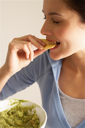 Woman Eating Chips and Dip Stock Photo - Premium Royalty-Free, Code: 600-00866871
