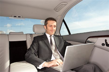 Homme d'affaires utilisant un ordinateur portable dans la voiture Photographie de stock - Premium Libres de Droits, Code: 600-00917020