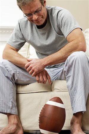 simsearch:600-00917160,k - Homme sur le canapé avec le Football Photographie de stock - Premium Libres de Droits, Code: 600-00917142