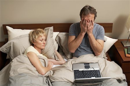 se frotter les yeux - Couple avec ordinateur portable dans le lit Photographie de stock - Premium Libres de Droits, Code: 600-00917165