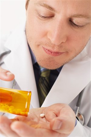 simsearch:600-00918175,k - Doctor Holding bouteille de pilules Photographie de stock - Premium Libres de Droits, Code: 600-00917394