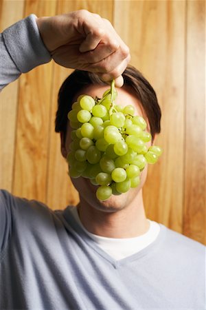 Man Covering Face with Grapes Stock Photo - Premium Royalty-Free, Code: 600-00934344