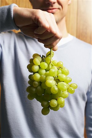 Man Holding Bunch of Grapes Stock Photo - Premium Royalty-Free, Code: 600-00934343