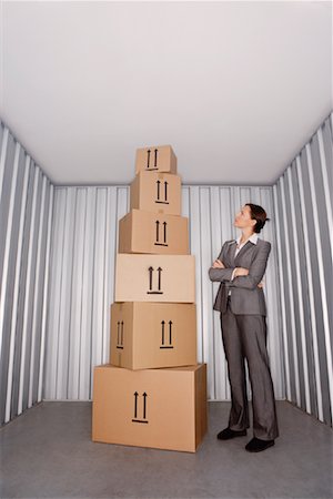 simsearch:600-01519632,k - Woman Looking at Pile of Boxes in Storage Stock Photo - Premium Royalty-Free, Code: 600-00933841