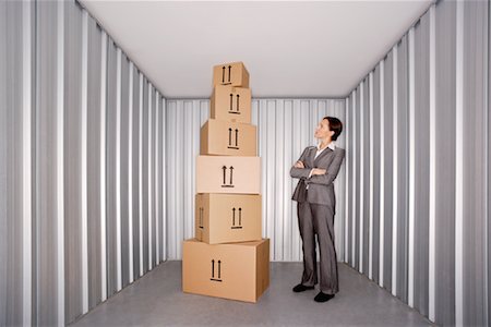 simsearch:600-01519632,k - Woman Looking at Pile of Boxes in Storage Stock Photo - Premium Royalty-Free, Code: 600-00933842