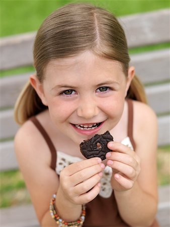 Portrait of Girl Eating Cookie Foto de stock - Royalty Free Premium, Número: 600-00948584