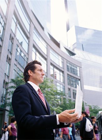 piggyback (gain free internet access) - Businessman Holding Laptop Computer in City Stock Photo - Premium Royalty-Free, Code: 600-00948871