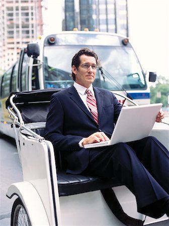 sneaky businessman laptop - Homme d'affaires avec ordinateur portable, assis en Rickshaw Photographie de stock - Premium Libres de Droits, Code: 600-00948937