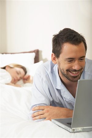 Couple in Bed, Man Using Laptop Stock Photo - Premium Royalty-Free, Code: 600-00955604