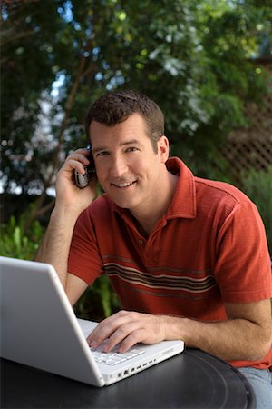 small business phone outside - Man in Backyard using Cell Phone and Computer Stock Photo - Premium Royalty-Free, Code: 600-00984111