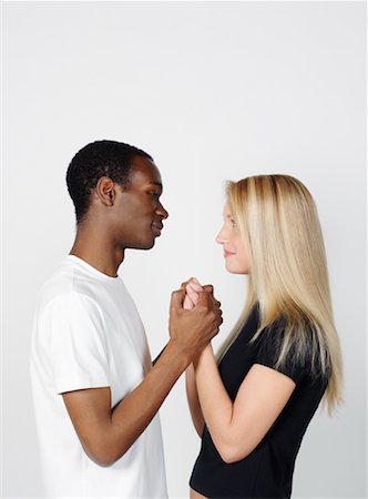 picture of white and black people holding hands - Couple Looking at Each Other and Holding Hands Stock Photo - Premium Royalty-Free, Code: 600-00983708