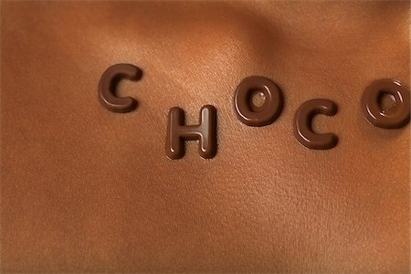 Close-up of Chocolate Letters on Woman's Chest Stock Photo - Premium Royalty-Free, Code: 600-01036929