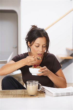 Woman Reading While Eating Cereal Stock Photo - Premium Royalty-Free, Code: 600-01041206