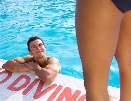 Man in Swimming Pool Looking up at Woman Stock Photo - Premium Royalty-Free, Code: 600-01041637