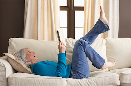 simsearch:600-01428963,k - Woman Reading Book on Sofa Foto de stock - Royalty Free Premium, Número: 600-01041770