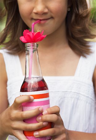 Close-up of Girl Holding Bottle of Soda Pop Stock Photo - Premium Royalty-Free, Code: 600-01041981
