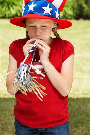 fourth of july hat - Portrait of Girl Wearing Stars and Stripes Hat and Blowing Noisemaker Horn Stock Photo - Premium Royalty-Free, Code: 600-01042010