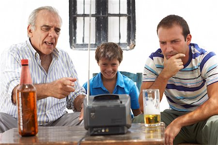 Grandfather, Father and Son Watching Television in Backyard Stock Photo - Premium Royalty-Free, Code: 600-01043370