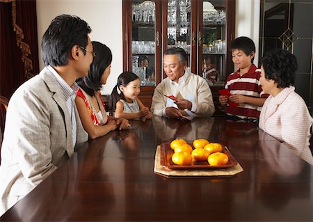 simsearch:600-01572011,k - Family Sitting around Dining Table Foto de stock - Sin royalties Premium, Código: 600-01073109